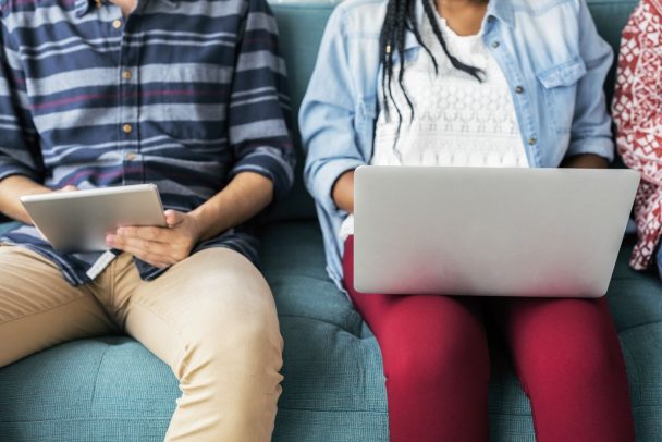 Two people on the sofa holding Microsoft computer devices
